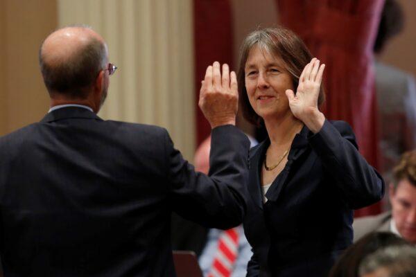 In this file photo, state Sens. Nancy Skinner (D-Berkeley) and Steven Glazer (D-Orinda) high-five in celebration after a measure was approved by the Senate in Sacramento, Calif., on Sept. 11, 2019. (Rich Pedroncelli/AP Photo)