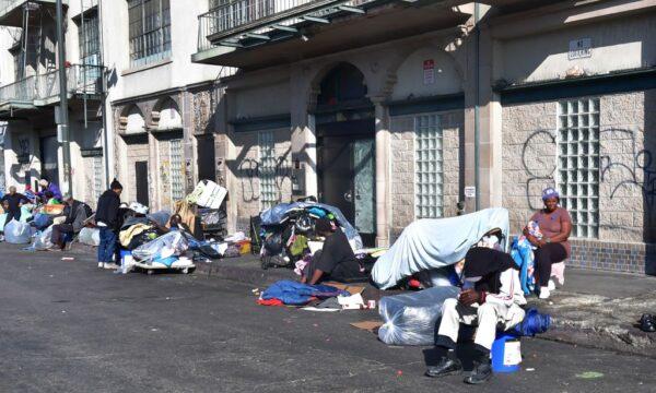 Homeless men and women sit out on a sidewalk in Los Angeles, Calif., on Jan. 8, 2020. (Frederic J. Brown/AFP via Getty Images)