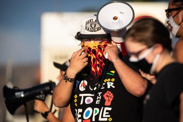 A protester walks along Yucaipa Boulevard in Yucaipa, Calif., on Aug. 1, 2020. (John Fredricks/The Epoch Times)