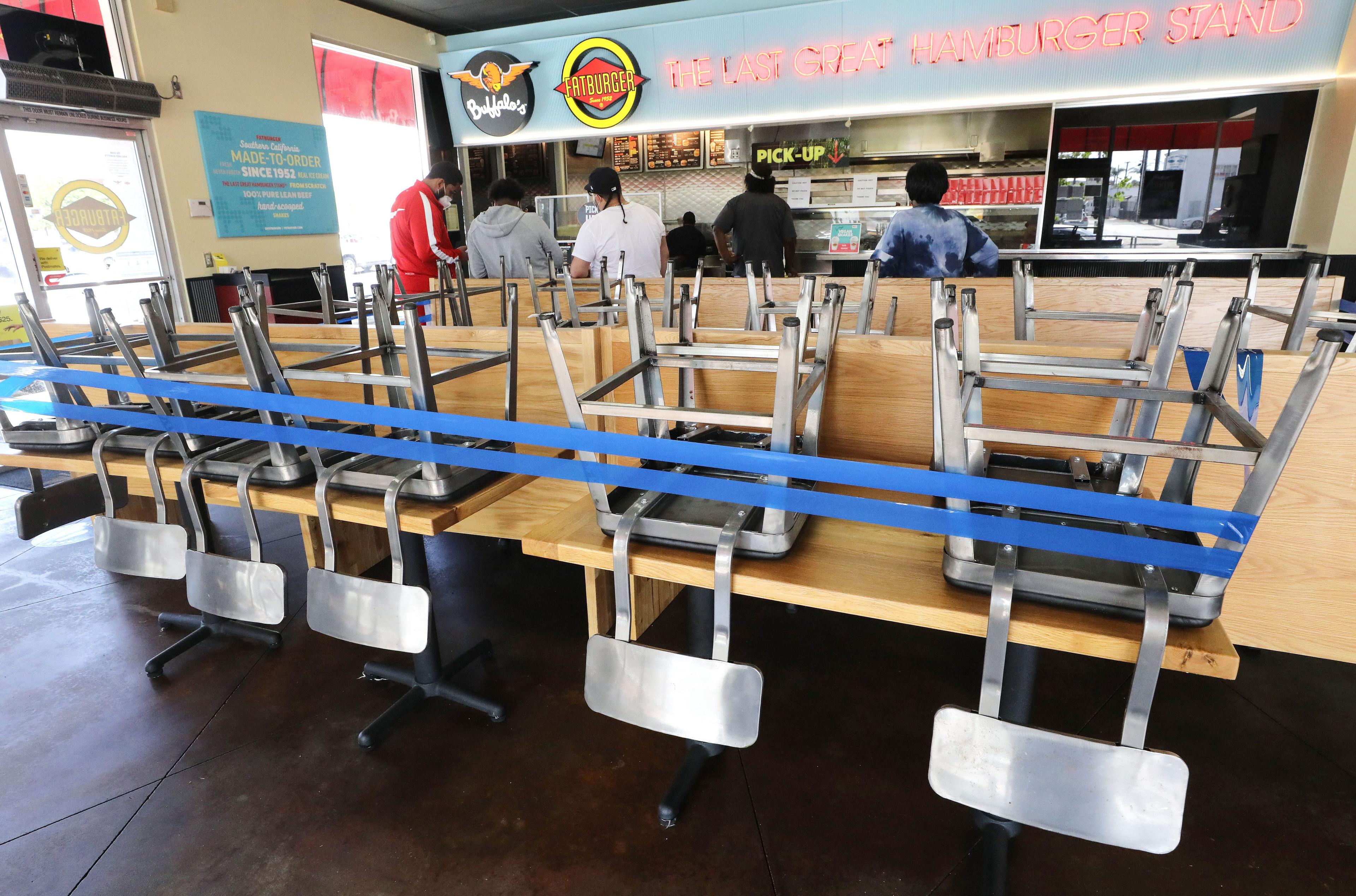 People wait for takeout orders near the closed dine-in section at a Fatburger restaurant in Inglewood, Calif., on July 1, 2020. (Mario Tama/Getty Images)