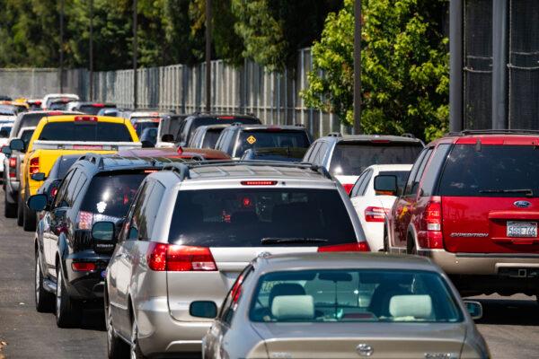 Cars line up to receive food distributed by Saddleback Church at Savanna High School in Anaheim, Calif., on Aug. 18, 2020. (John Fredricks/The Epoch Times)