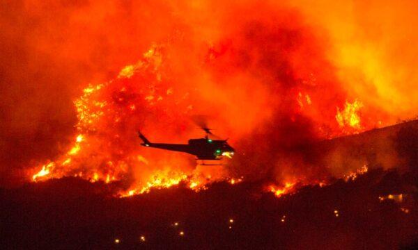 A helicopter prepares to drop water at a wildfire in Yucaipa, Calif., on Sept. 5, 2020. (Ringo H.W. Chiu/AP Photo)