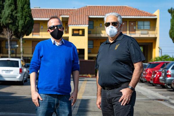 Jason Austin, director of care and coordination for the Orange County Health Care Association (L) and Paul Leon, CEO, Illumination Foundation (R) stand in front of the Stanton Inn, a Project Roomkey site that will transfer over to Project Homekey, in Stanton, Calif., on Oct. 8, 2020. (John Fredricks/The Epoch Times)