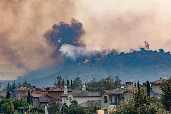 A firefighting helicopter drops water on the Blue Ridge Fire in Chino Hills, Calif., on Oct. 27, 2020. (John Fredricks/The Epoch Times)