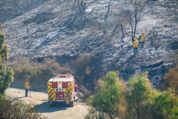 Firefighters inspect the charred residue of the Blue Ridge Fire in Orange County, Calif., on Oct. 29, 2020. (John Fredricks/The Epoch Times)