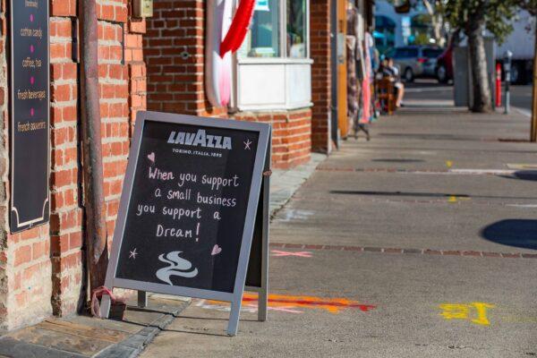 A sign stands on the sidewalk in front of The Rocky Mountain Chocolate Factory in Laguna Beach, Calif., on Nov. 18, 2020. (John Fredricks/The Epoch Times)