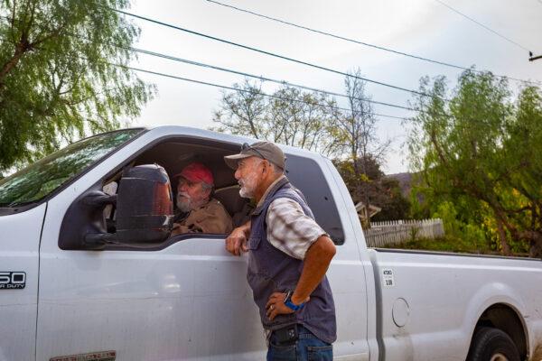 Gil Iwamoto (R) talks to a passing neighbor in Williams Canyon, Calif., on Dec. 23, 2020. (John Fredricks/The Epoch Times)