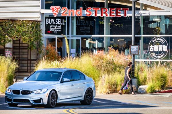 A woman walks past a small business in Costa Mesa, Calif., on Nov. 16, 2020. (John Fredricks/The Epoch Times)