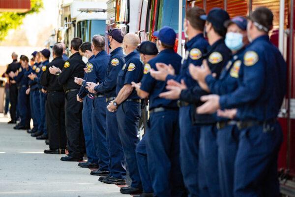 Orange County Fire Authority Firefighters clap for Dylan Van Iwaarden as he was released from Orange County Global Medical Center in Santa Ana, Calif., on Feb. 17, 2021, after receiving treatments from injuries sustained in last October's Silverado Fire. (John Fredricks/The Epoch Times)
