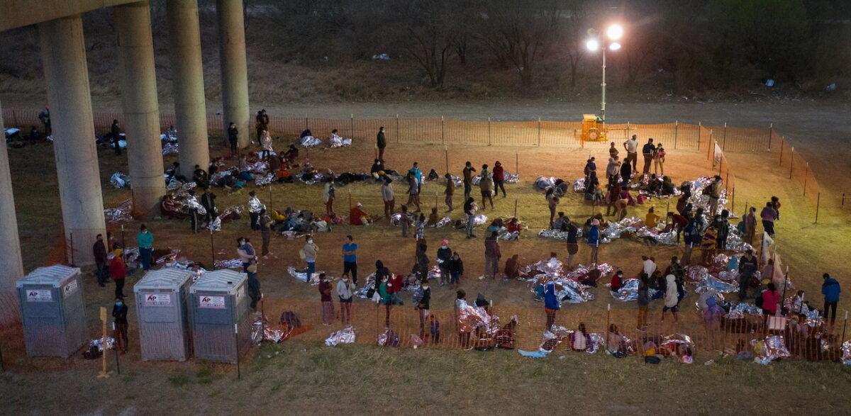 Illegal immigrants from Central America take refuge in a make shift U.S. Customs and Border Protection processing center under the Anzalduas International Bridge after crossing the Rio Grande river into the United States from Mexico, in Granjeno, Texas, on March 12, 2021. (Adrees Latif/Reuters)