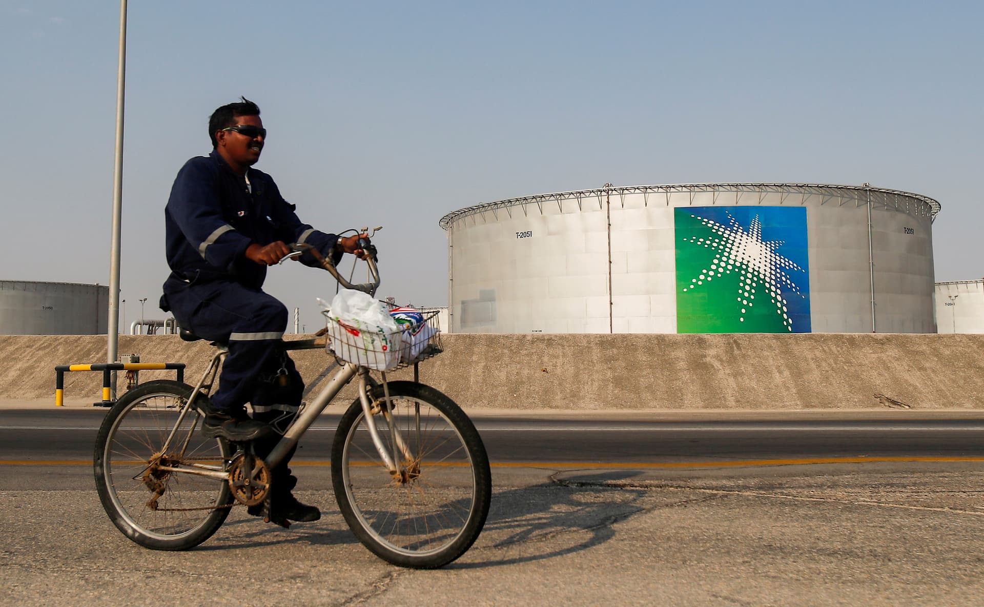 An employee rides a bicycle next to oil tanks at Saudi Aramco oil facility in Abqaiq, Saudi Arabia, on Oct. 12, 2019. (Maxim Shemetov/Reuters)