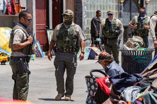 A law enforcement officer speaks to a man on Venice Beach, Calif., on June 8, 2021. (John Fredricks/The Epoch Times)