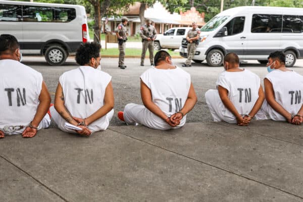 Illegal immigrants wait to be magistrated on trespassing charges in Kinney County outside the Sheriff's Office in Brackettville, Texas, on Aug. 6, 2021. (Charlotte Cuthbertson/The Epoch Times)