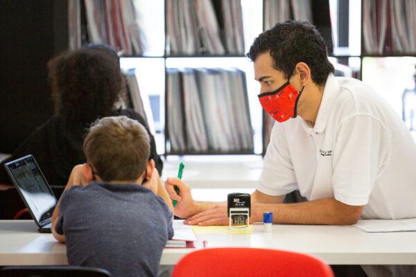 An instructor helps a student perform a math assignment at Mathnasium in Laguna Niguel, Calif., on May 12, 2021. (John Fredricks/The Epoch Times)