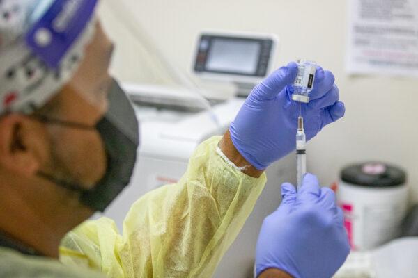 A medical volunteer prepares the Moderna coronavirus vaccination for a patient at Lestonnac Free Clinic in Orange, Calif., on March 9, 2021. (John Fredricks/The Epoch Times)