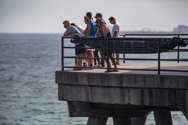People gather to watch surfers practice for the US Open of Surfing in Huntington Beach, Calif., on Sept. 22, 2021. (John Fredricks/The Epoch Times)