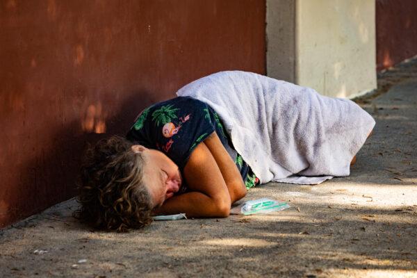 A homeless individual sleeps on the streets of Santa Ana, Calif., on Sept. 4, 2020. (John Fredricks/The Epoch Times)