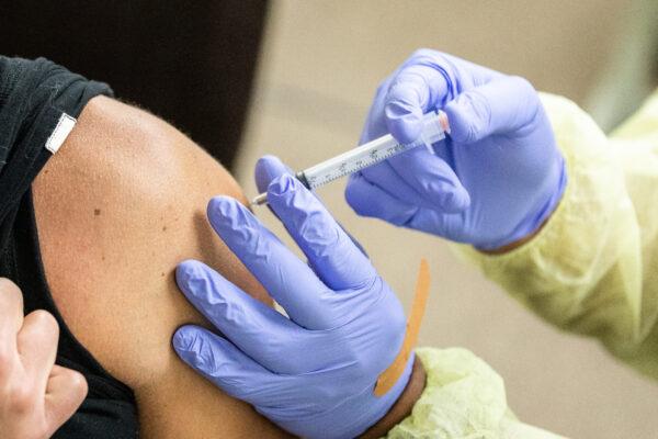 A medical volunteer prepares the Moderna coronavirus vaccination for a patient at Lestonnac Free Clinic in Orange, Calif., on March 9, 2021. (John Fredricks/The Epoch Times)