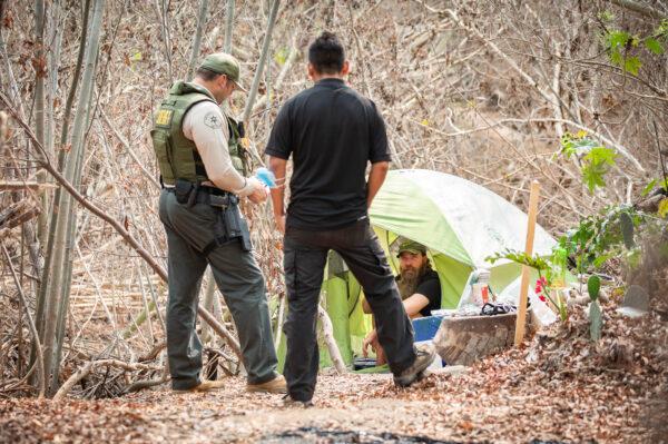 Members of the Los Angeles Sheriff's Department Homeless Outreach Services Team (HOST) and the Los Angeles Services Authority offer homeless residents food, water, and transportation and housing options in Malibu, Calif., on Sept. 23, 2021. (John Fredricks/The Epoch Times)