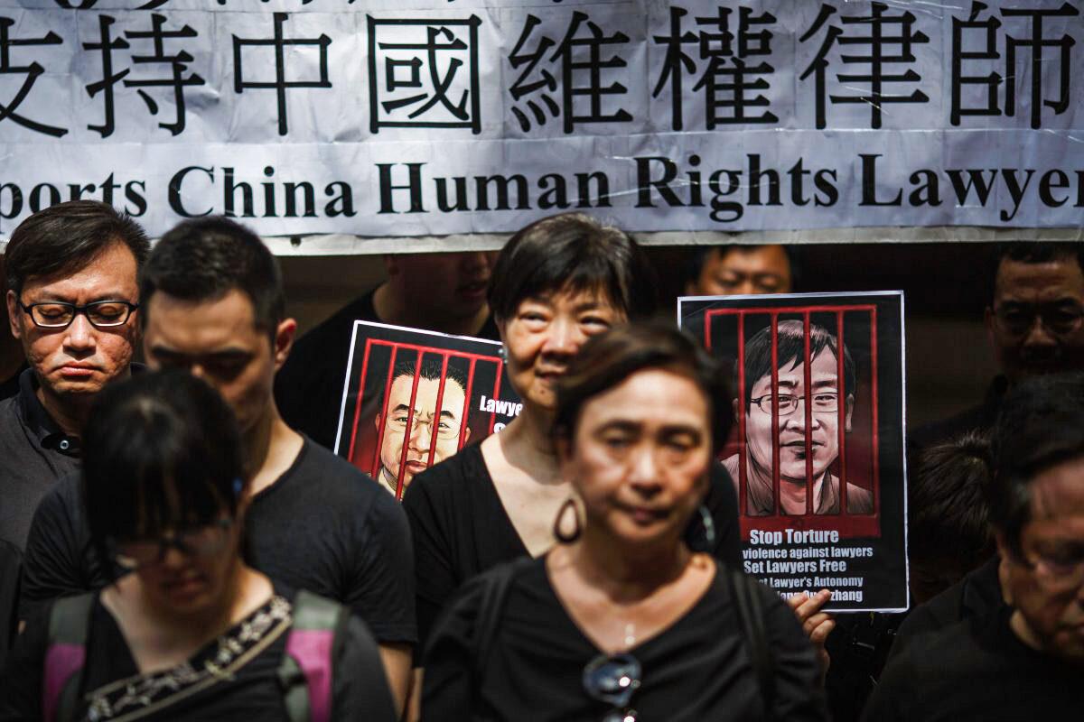 Portraits of detained Chinese human rights lawyers Jian Tianyong (L) and Wang Quanzhang are seen as Hong Kong pro-democracy activists observe a silent protest in support of human rights lawyers in China, outside the Court of Final Appeal in Hong Kong's Central district on July 9, 2017. (Tengku Bahar/AFP/Getty Images)