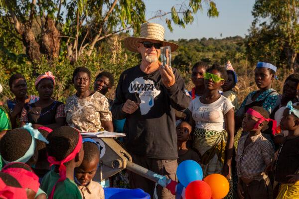 Water Wells for Africa founder Kurt Dahlin tests the water with Juma 2B villagers on July 2, 2021. (John Fredricks/The Epoch Times)