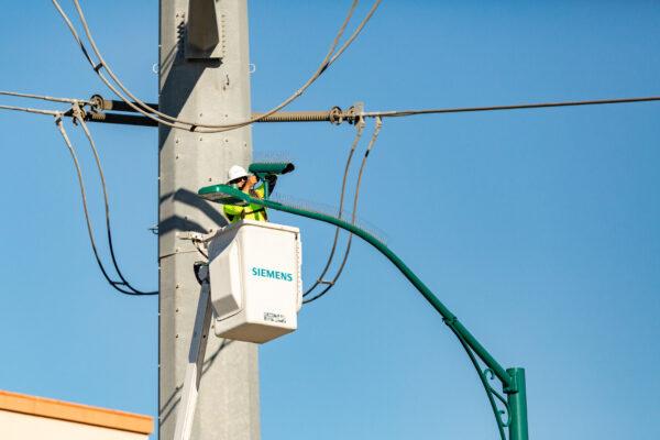 A technician adjusts a traffic camera on Beach Boulevard in Anaheim, Calif., Feb. 23, 2021. (John Fredricks/The Epoch Times)