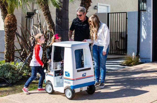Seven-year-old Jacob Hayward receives gifts from his favorite mailman from the United States Postal Service, Van Singletary, at his home in Laguna Niguel, Calif., on Jan. 24, 2022. (John Fredricks/The Epoch Times)