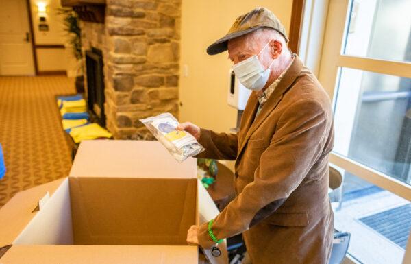 Resident Ron Lackie helps other seniors and medical staff at The Orchards Health Center create and load first-aid kits to be delivered to Ukraine in Ranch Mission Viejo, Calif., on March 15, 2022. (John Fredricks/The Epoch Times)