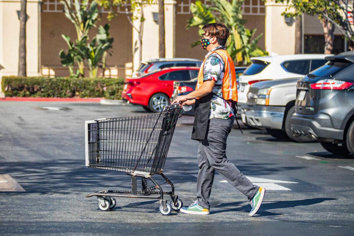 A worker at Ralphs returns a shopping cart to the store in Irvine, Calif., on Feb. 5, 2021. (John Fredricks/The Epoch Times)