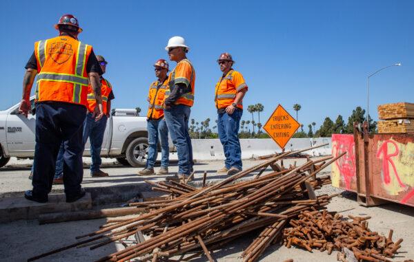 Construction workers chat in Costa Mesa, Calif., on April 21. 2022. (John Fredricks/The Epoch Times)