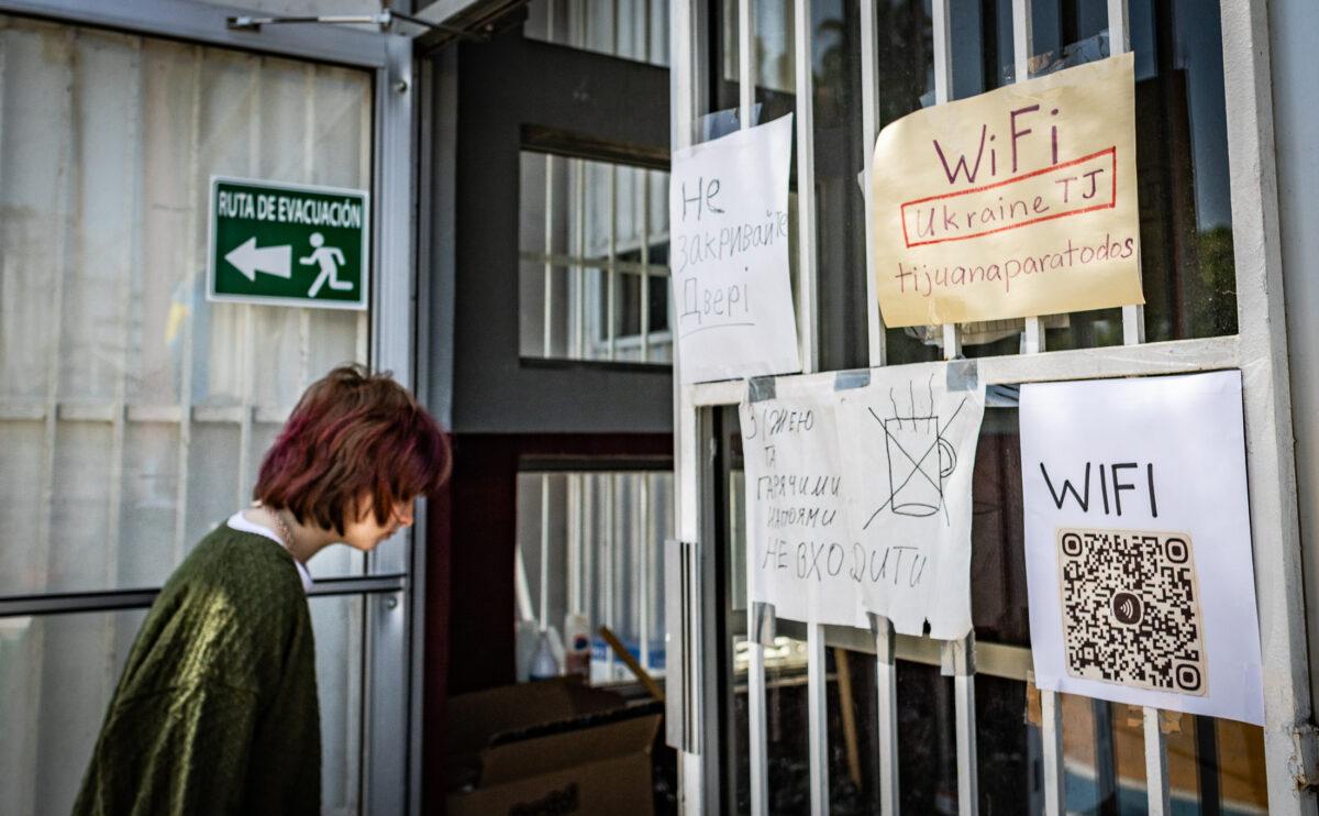 A woman walks into the sleeping area of the Benito Juarez Sports Complex of Tijuana, Mexico, on April 27, 2022. (John Fredricks/The Epoch Times)