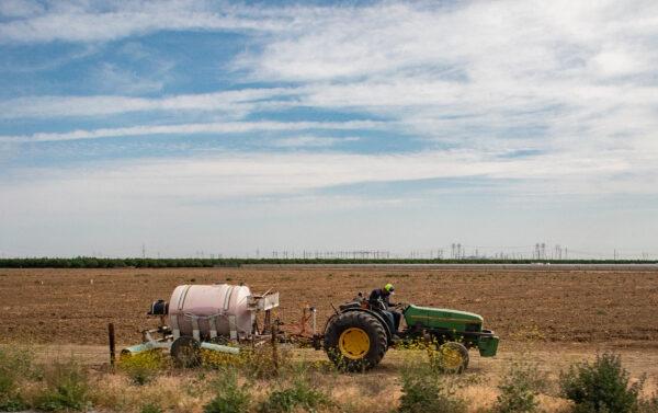A farmer uses a tractor outside of Sacramento, Calif., on April 18, 2022. (John Fredricks/The Epoch Times)