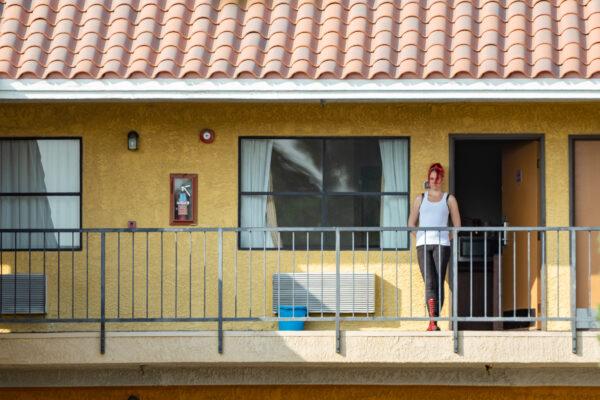 A Project Roomkey participant stands outside her door at The Stanton Inn in Stanton, Calif., on Oct. 8, 2020. (John Fredricks/The Epoch Times)