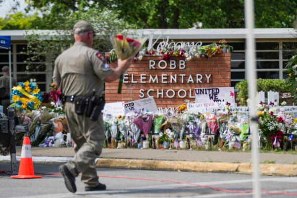 A makeshift memorial at Robb Elementary School is filled with flowers, toys, signs, and crosses bearing the names of all 21 victims of the mass shooting that occurred on May 24, in Uvalde, Texas, on May 27, 2022. (Charlotte Cuthbertson/The Epoch Times)