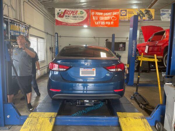 A car has its catalytic converter etched for free at Buddy's Auto Tires and More as part of a concerted effort with the California Auto Club, Garden Grove Police Department, and Sen. Tom Umberg's (D-Santa Ana) office in Garden Grove, Calif., on June 13, 2022. (Carol Cassis/The Epoch Times)