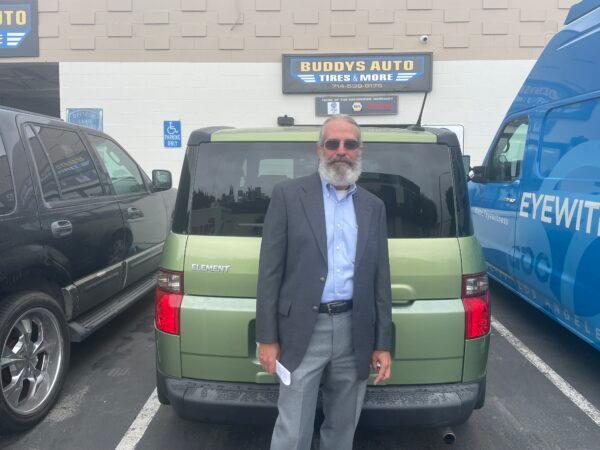 Corwin Brown poses with his newly repaired car after his catalytic converter was stolen one month prior in Garden Grove, Calif., on June 13, 2022. (Carol Cassis/The Epoch Times)