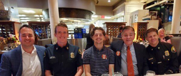 In attendance at the Mr. Irrelevant Dinner, sitting at table book-ended by Jesse Sapolu, and the Newport Beach Mayor (L to R) Kevin Muldoon, Newport Lifeguard Captain Andy White, Braeden Boyles, Gary Boyles, and Newport Fire Chief Jeff Boyles, at The Cannery restaurant, in Newport Beach, Calif., on June 20, 2022. (Nhat Hoang/The Epoch Times)