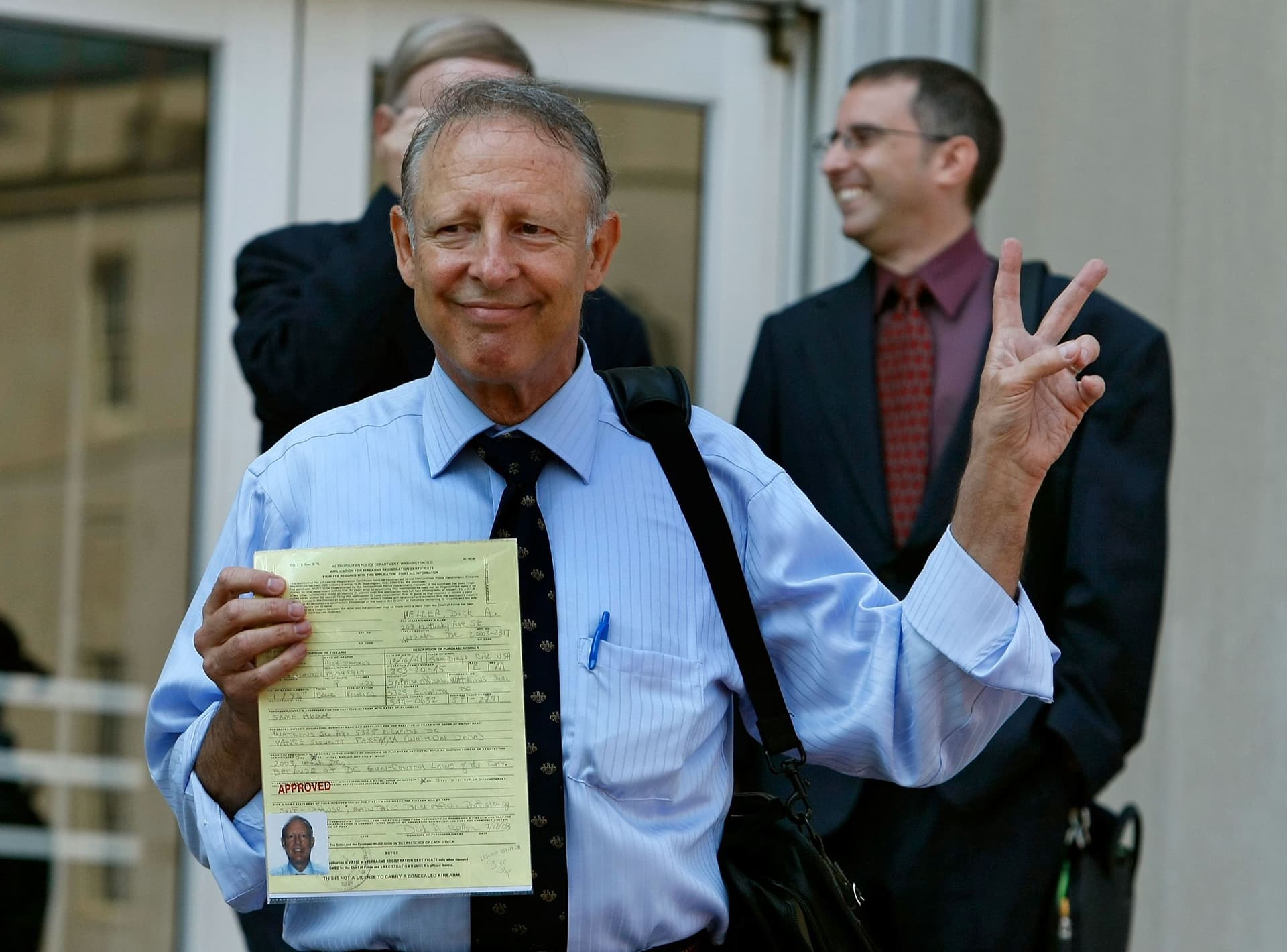 Dick Heller, plaintiff in the Supreme Court case Heller v. District of Columbia, gestures while holding his newly approved gun permit at the District of Columbia Police Department on Aug. 18, 2008. (Mark Wilson/Getty Images)