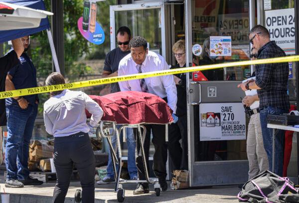 Authorities remove a body from a 7-Eleven after a clerk was fatally shot during a robbery in Brea, Calif., on July 11, 2022. (Mindy Schauer/The Orange County Register via AP)