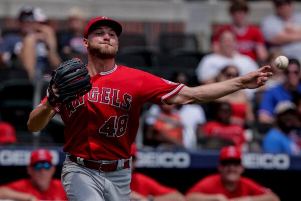 Los Angeles Angels starting pitcher Reid Detmers makes an errant throw to first on a hit by Atlanta Braves' Guillermo Heredia during the fifth inning of a baseball game, in Atlanta, on Sunday, July 24, 2022. (Butch Dill/AP Photo)
