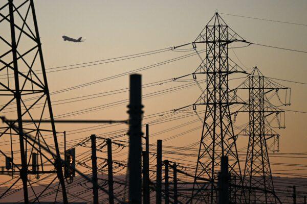 An aircraft takes off from Los Angeles International Airport behind electric power lines in El Segundo, Calif., on Aug. 31, 2022. (Patrick T. Fallon/AFP via Getty Images)