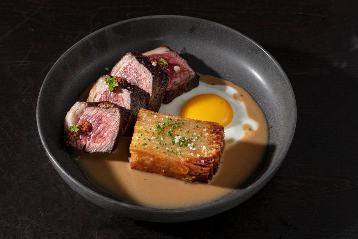 The bitoque, a Portguese-style steak-and-egg dish, is served with steak Diane sauce and potato gratin. (Melissa Hom)