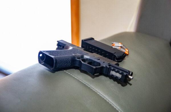 A firearm is confiscated by police officers in Westminster, Calif., on May 10, 2022. (John Fredricks/The Epoch Times)