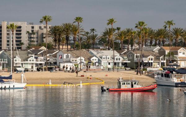 Law enforcement officials investigate the crash site of a Huntington Beach Police Department helicopter that crashed into Newport Harbor on the night of Feb. 19, 2022. Newport Beach, Calif., on Feb. 20, 2022. (John Fredricks/The Epoch Times)