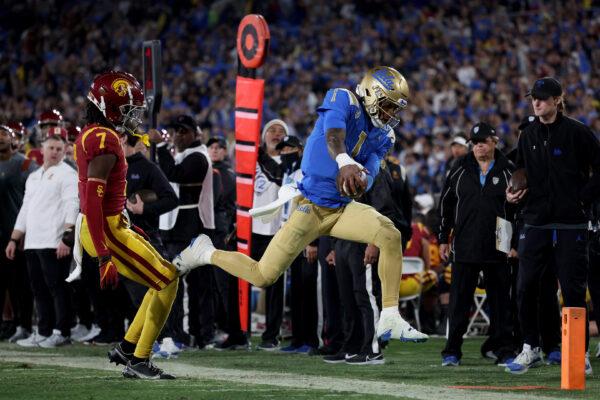 Dorian Thompson-Robinson (1) of the UCLA Bruins reaches for the first down as he goes out of bounds against Calen Bullock (7) of the USC Trojans during the third quarter in the game at Rose Bowl in Pasadena, Calif., on Nov. 19, 2022. (Harry How/Getty Images)