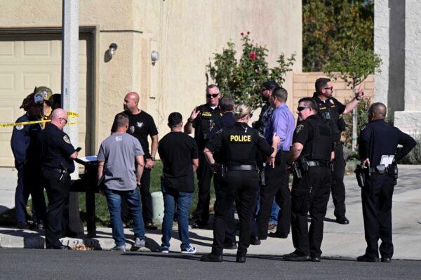Firefighters and Riverside Police gather outside a burned home following a house fire in Riverside, Calif., on Nov. 25, 2022. Three bodies were found in the house which police are investigating as a homicide. (Will Lester/Inland Valley Daily Bulletin/SCNG via AP)