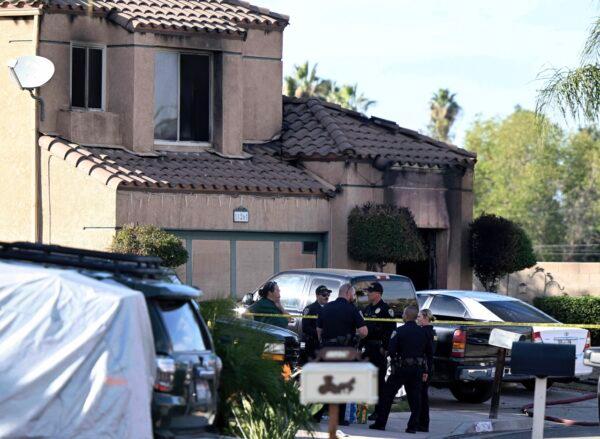 Firefighters and Riverside Police gather outside a burned home following a house fire in Riverside, Calif., on Nov. 25, 2022. Three bodies were found in the house which police are investigating as a homicide. (Will Lester/Inland Valley Daily Bulletin/SCNG via AP)