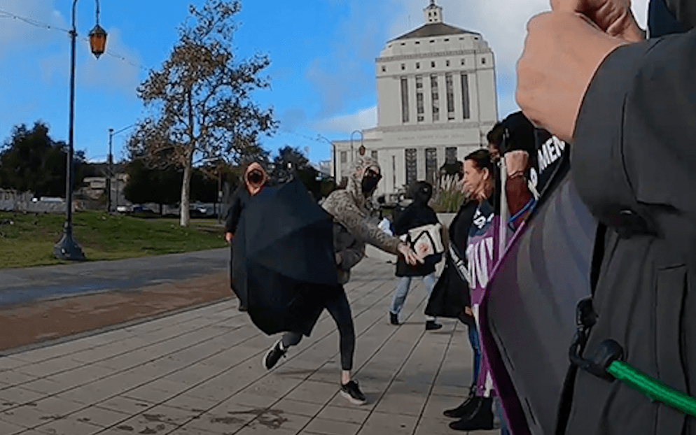 Women protesting the possible transfer of convicted killer Dana Rivers—a biological man who identifies as female—to a women’s prison are attacked outside of the Alameda County Superior Courthouse in Oakland, Calif., on Dec. 5, 2022. (Courtesy of Women's Declaration International, U.S.A.)