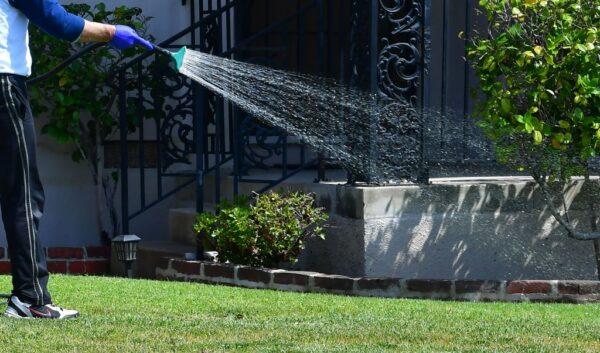 A man waters his lawn in Alhambra, Calif., on April 27, 2022. (Frederic J. Brown/AFP via Getty Images)