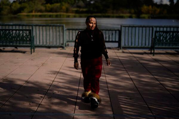 Moonlight Pulido stands by the shore at Harbor Lake in Los Angeles, on Dec. 7, 2022. (Marcio Jose Sanchez/AP Photo)